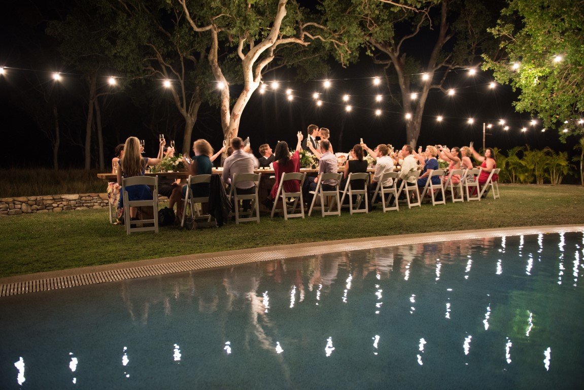 Whitsundays wedding party outside at night with lights and long table 
