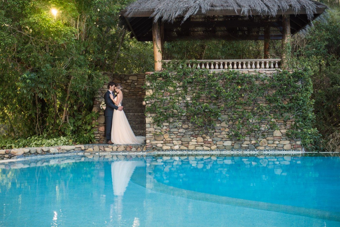 Bride and Groom by a pool and wedding reception at Paradise Cove Resort